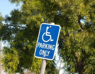 Blue and white ADA sign to indicate a reserved parking space for those with disabilities near Greeneville, TN
