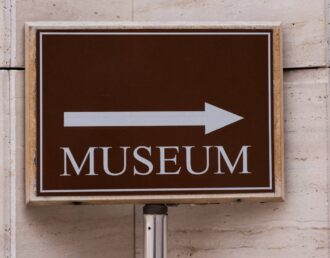 A directional sign with an arrow pointing right, indicating the museum in that area at Greeneville Signs near Greeneville, TN