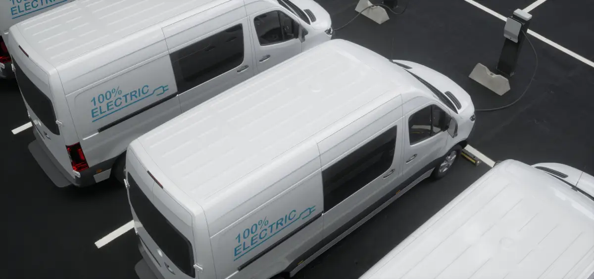 An image of four commercial vans with custom fleet wraps advertising an electric business